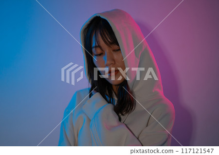 一位身穿白色連帽衫、頭戴兜帽的年輕女子的肖像 117121547