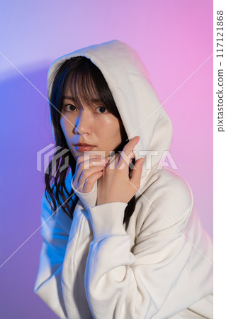 一位身穿白色連帽衫、頭戴兜帽的年輕女子的肖像 117121868