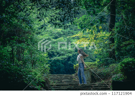 A woman running up a staircase surrounded by natural greenery 117121904