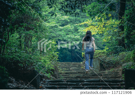A woman running up a staircase surrounded by natural greenery A woman running up a staircase surrounded by natural greenery 117121906