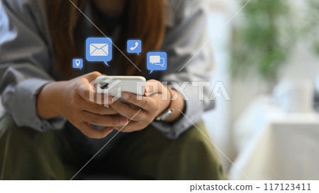 Female hands using smartphone with notification icons. Communication and technology concept 117123411