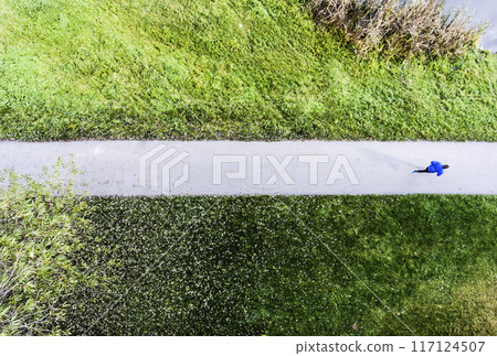 Aerial view of a runner running through the park on a jogging path. Morning running training. 117124507