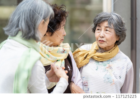 Three senior women standing and talking 117125225