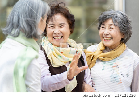 Three senior women standing and talking 117125226