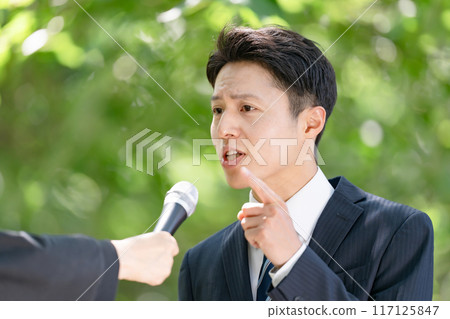 A man giving a passionate speech during a street interview 117125847