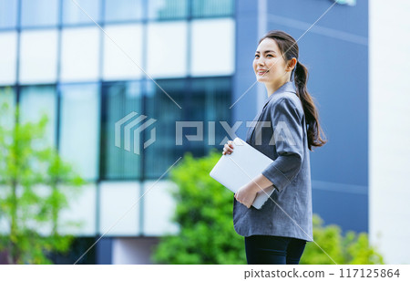 Business woman walking with a PC Business woman walking with a PC 117125864
