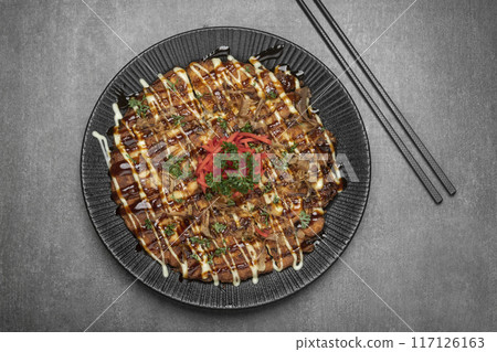 Okonomiyaki traditional japanese savoury pancake dish in restaurant on grey background 117126163