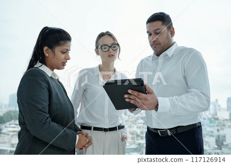 Colleagues Discussing Online Presentation In Office 117126914