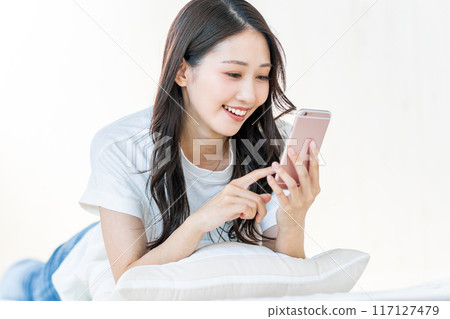 觀看有微笑的婦女一個智能手機 117127479