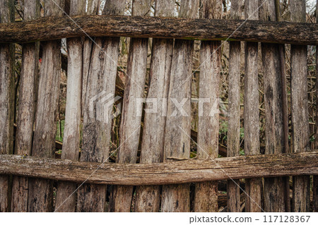 Outdated wooden fence in old village, wood planks, texture 117128367