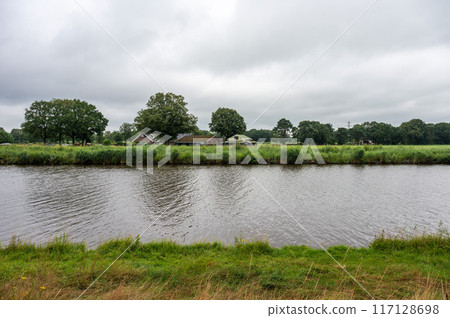 The Twente canal and green surroundings on a cloudy and rainy day around Markelo, Overijssel, The Netherlands 117128698