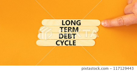Long term debt cycle symbol. Concept words Long term debt cycle on wooden stick. Beautiful orange table orange background. Businessman hand. Business Long term debt cycle concept. Copy space. Long term debt cycle symbol. Concept words Long term debt cycle on wooden stick. Beautiful orange table orange background. Businessman hand. Business Long term debt cycle concept. Copy space. 117129443