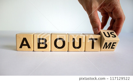 Hand turns a cube and changes the expression 'about me' to 'about us'. Beautiful white background. Business concept. Copy space. Hand turns a cube and changes the expression 'about me' to 'about us'. Beautiful white background. Business concept. Copy space. 117129522