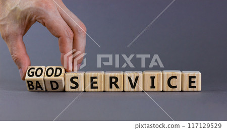 Good or bad service symbol. Businessman turns cubes and changes words bad service to good service. Beautiful grey table grey background. Business good or bad service concept, copy space. Good or bad service symbol. Businessman turns cubes and changes words bad service to good service. Beautiful grey table grey background. Business good or bad service concept, copy space. 117129529