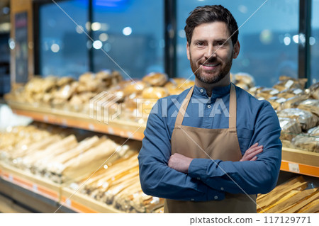 Confident baker standing with arms crossed in bakery shop surrounded by fresh bread. Person showcasing pride in craftsmanship and dedication to baking. Background displays variety of breads Confident baker standing with arms crossed in bakery shop surrounded by fresh bread. Person showcasing pride in craftsmanship and dedication to baking. Background displays variety of breads 117129771