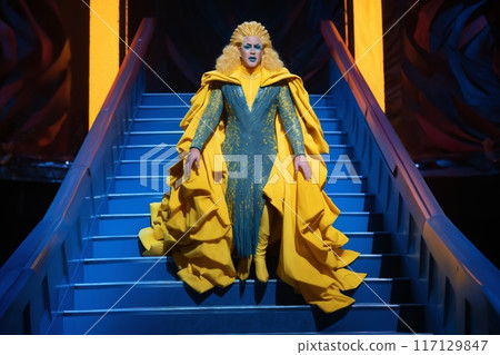 portrait of a man, singer or dancer, dressed in a luxurious concert costume, walking down the steps to the show stage 117129847