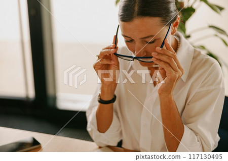 A Focused and Dedicated Professional Woman Engaged in Working Within a Modern Office Environment 117130495