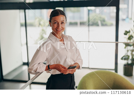 A Confident Businesswoman in a Modern Office Setting, Representing Strength and Professionalism A Confident Businesswoman in a Modern Office Setting, Representing Strength and Professionalism 117130618