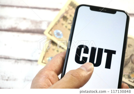 A smartphone with the word "CUT" on it and a 10,000 yen note A smartphone with the word "CUT" on it and a 10,000 yen note 117130848