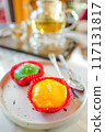 Close focus on an orange chinese style cake with blurry background of hot tea set. 117131817