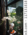 The ancient chinese style vase with artificial white flowers in the glass corner. 117131818
