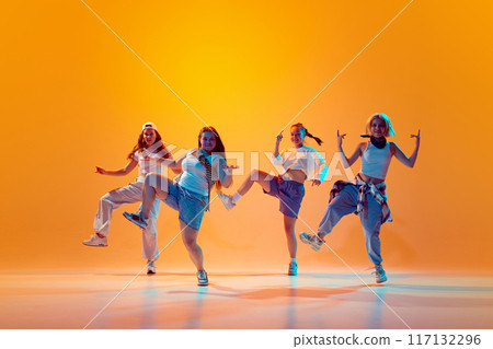 Dynamic photo of young energetical women quartet performing in vibrant neon light against gradient studio background. Dynamic photo of young energetical women quartet performing in vibrant neon light against gradient studio background. 117132296
