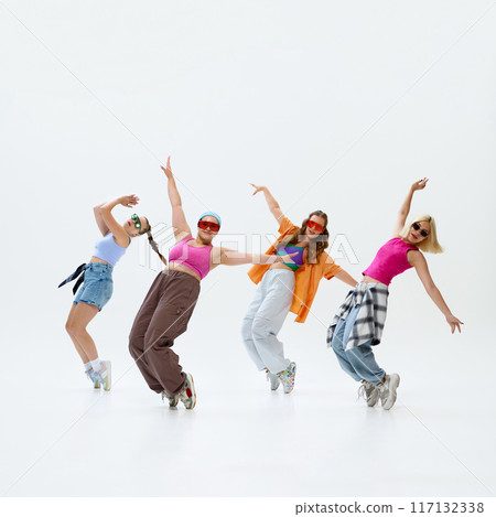 Young dancers, girls dancing in retro-fashion outfits against white studio background. Rhythm of youth throw moves. 117132338
