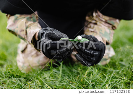 A man in a special suit works with a detector and found an explosive device. A man tries to neutralize high-explosive anti-personnel pressure mine 117132558