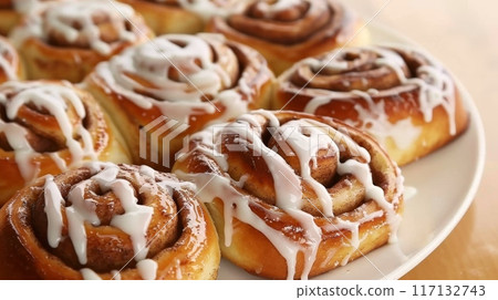 Freshly Baked Cinnamon Rolls Drizzled with Creamy Icing 117132743