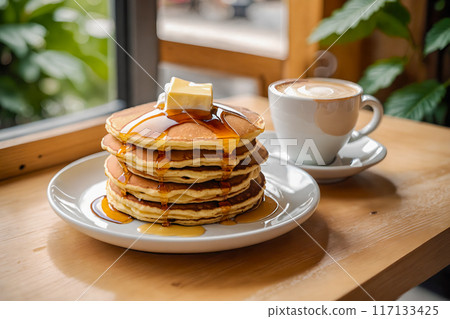 Stacks of pancakes and cafe latte placed on a cafe table. 117133425