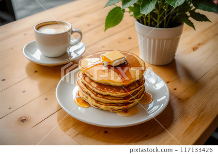 Stacks of pancakes and cafe latte placed on a cafe table. 117133426