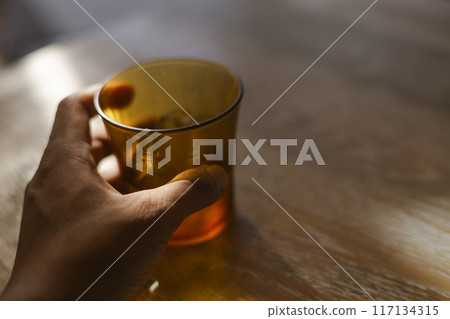 拿著棕色玻璃的男性手 117134315