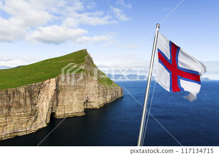 National Faroese flag waving against a background of Vagar island National Faroese flag waving against a background of Vagar island 117134715