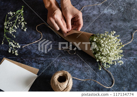 Gardener's in the flower shop make bouquet for a holiday. Family flower's business. Lifestyle flower shop. Beautiful flower composition. Detail. Close up. 117134774
