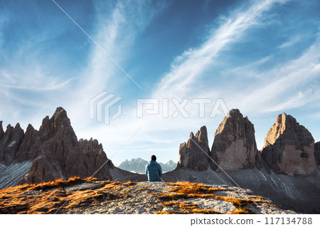 Tourist sitting on rock edge at Three Peaks of Lavaredo track 117134788