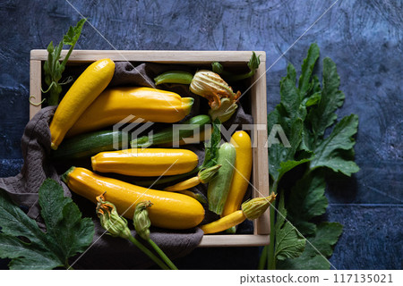 Slicing zucchini on a cutting board. Ripe zucchini on a gray background. Top view, horizontal. Slicing zucchini on a cutting board. Ripe zucchini on a gray background. Top view, horizontal. 117135021