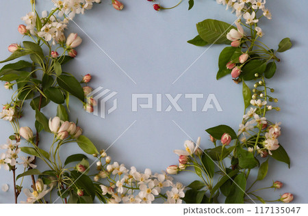 Floral layout on a vintage white wooden background and computer partially. Spring flowers, woman freelancing concept. View from above. 117135047