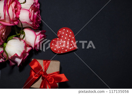Vertical Valentines Day background with blank paper card mockup, gifts, red hearts, confetti on pink. 117135056