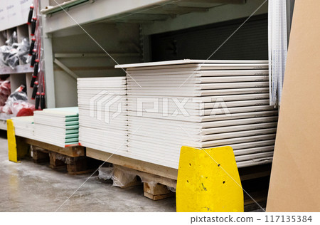 Drywall standard gypsum panels, wallboards plasterboard stacked in hardware store closeup Drywall standard gypsum panels, wallboards plasterboard stacked in hardware store closeup 117135384