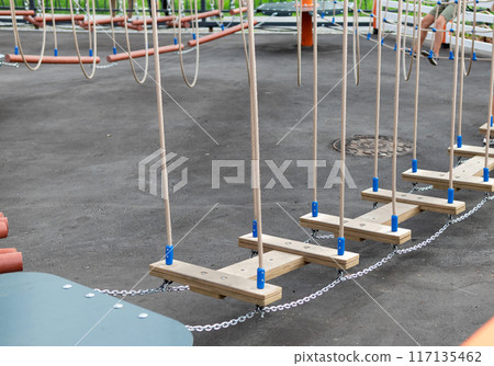 Children Playground with Modern Slide, Rope Net Bridge, Climbing Swings, Climbers. Empty Wooden Playground made of Eco Materials Children Playground with Modern Slide, Rope Net Bridge, Climbing Swings, Climbers. Empty Wooden Playground made of Eco Materials 117135462