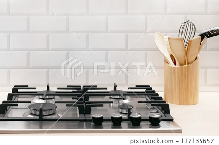 Front view of Contemporary tempered glass gas stove hob with Two burners with auto ignition knob on wooden countertop, cast iron pan supports fan hood and oven built in compact Front view of Contemporary tempered glass gas stove hob with Two burners with auto ignition knob on wooden countertop, cast iron pan supports fan hood and oven built in compact 117135657