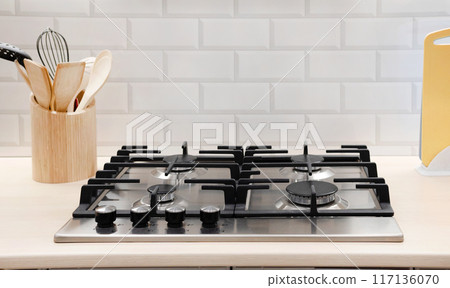 Modern hob gas stove countertop in big kitchen interior. Modern hob gas stove countertop in big kitchen interior. 117136070