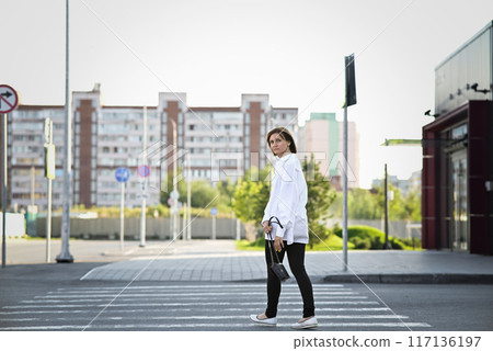 Woman crossing the road at a crosswalk 117136197