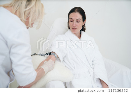 Woman in Spa Robe Receiving Blood Sample at Modern Medical Facility During Daytime 117136252