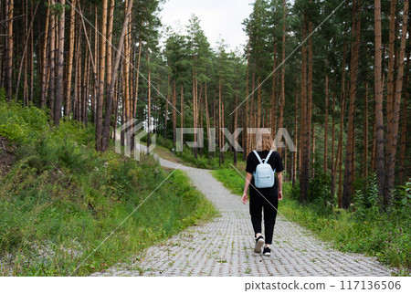 woman traveler with backpack and looking at amazing forest, wanderlust travel concept, space for text, atmospheric epic moment 117136506