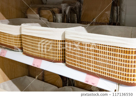 Empty wicker basket on kitchen table, against background of marble wall. basket for bread and fruit. 117136550