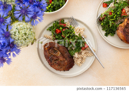 This delicious meal features savory turkey with gluten-free pasta, a vibrant salad of fresh vegetables and herbs, and ripe fruits, offering a nutritious and satisfying option  117136565