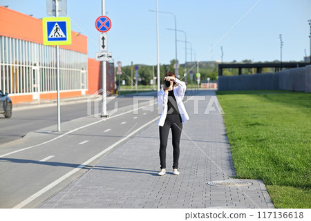 Beautiful woman taking picture outdoors with a analog camera 117136618
