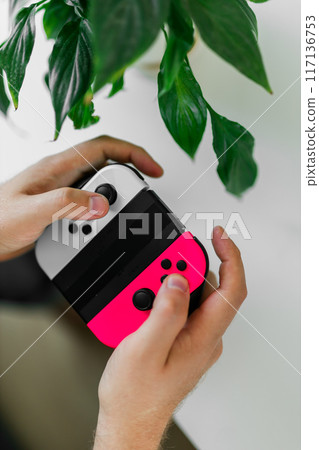Man playing video games in living room sitting on sofa. Man playing video games in living room sitting on sofa. 117136753