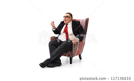 Fat man, businessman in formal wear, red tie and glasses, sitting in armchair and leading conversation, isolated on white background. Fat man, businessman in formal wear, red tie and glasses, sitting in armchair and leading conversation, isolated on white background. 117136810